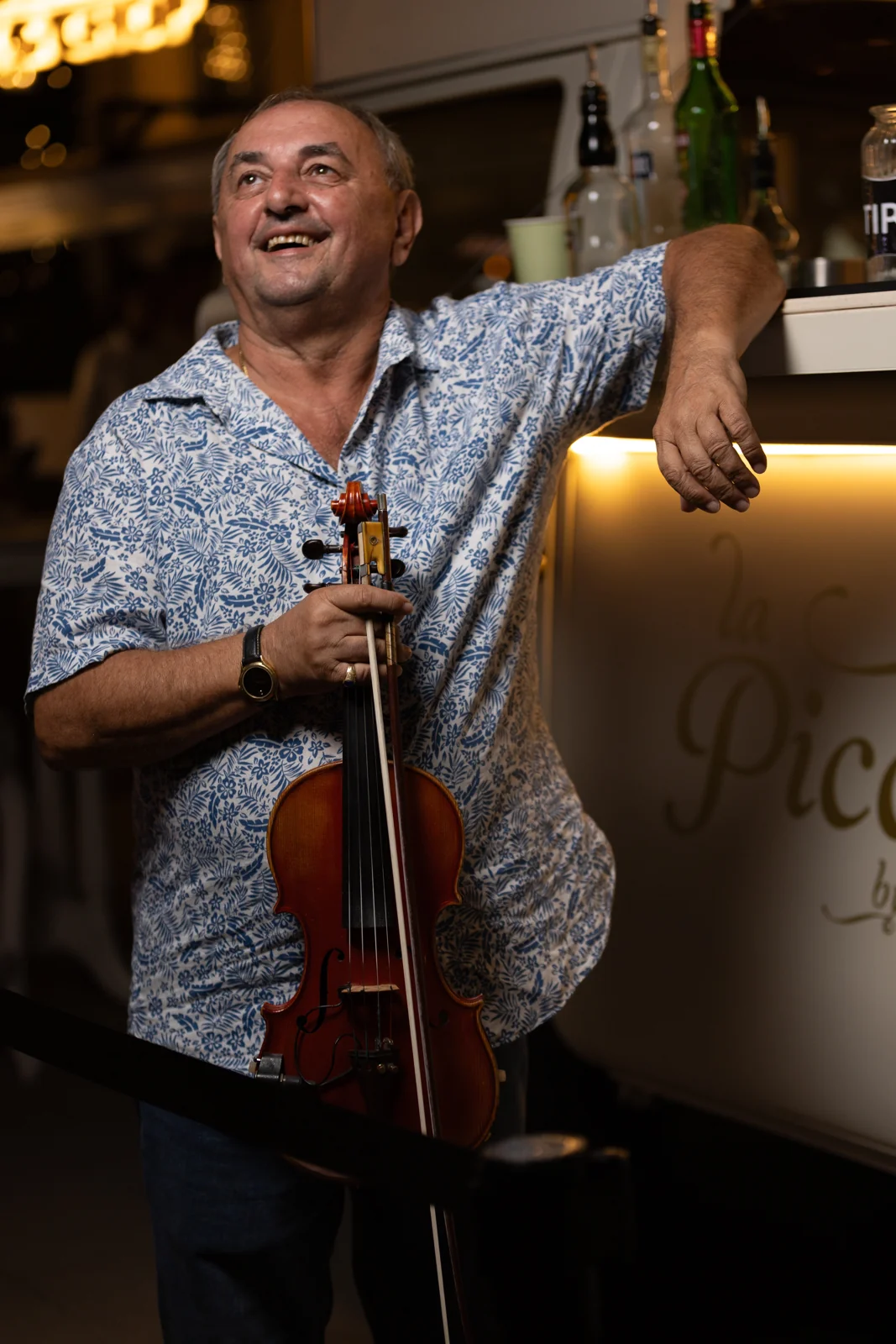 Nicola smiling with his violin on a restaurant terrace